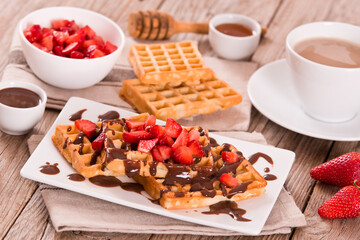 Waffles with strawberries and chocolate cream.
