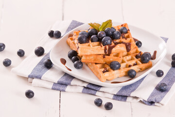 Waffles with blueberries and chocolate cream.

