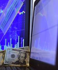 20 dollar banknotes on blurred background of computer screen and monitor with stock chart with disposable face mask