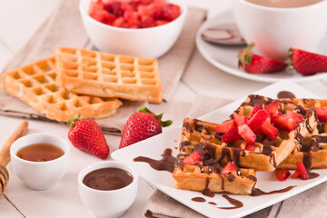 Waffles with strawberries and chocolate cream.
