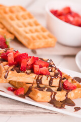 Waffles with strawberries and chocolate cream.
