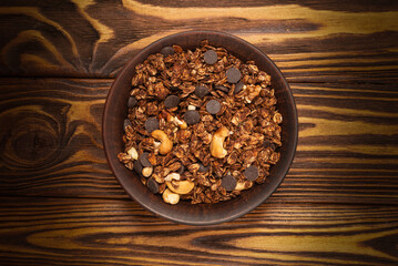 Chocolate granola cereal with nuts in a bowl.