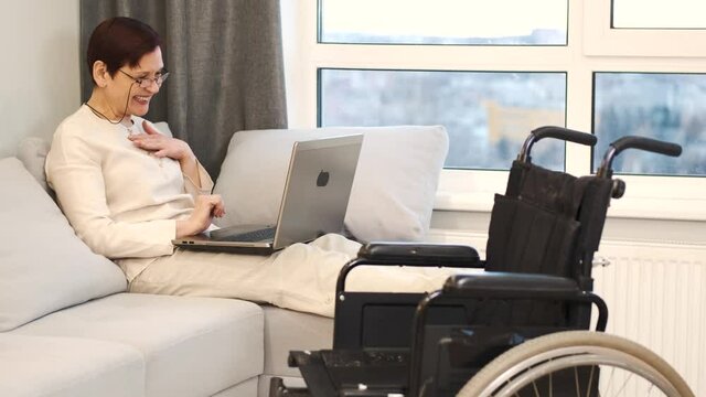 Handicapped woman with lapot lay on couch