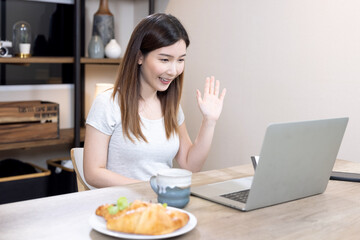 Asian woman speaks to her team of colleagues at an online video conference, Work from home.