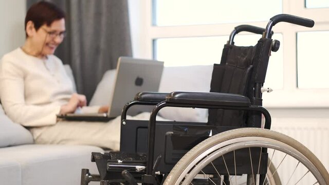 Handicapped woman with lapot lay on couch
