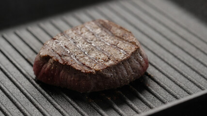 beef steak cooking on iron grill pan