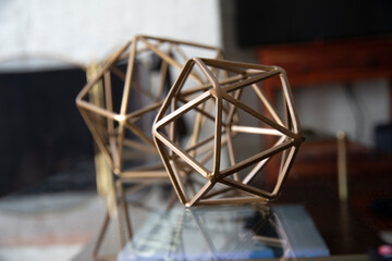 Fototapeta na wymiar Metal geometric tabletop home decoration. Polyhedron shape decorative interior element