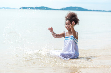 happy african american Little girl walking on the beach