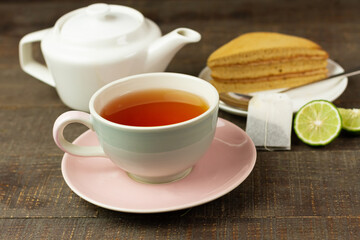 Bergamot tea or Earl Grey tea in ceramic cup and fresh bergamot fruit with sliced on brown wooden table.