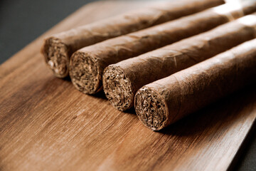 Group of brown cuban cigars on wooden background