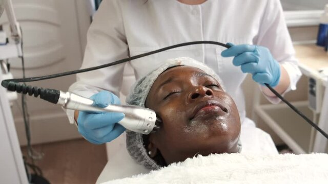 Beautician makes procedure for clean face with hardware