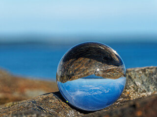 Fototapeta na wymiar Spectacular rocky shore of Sidney BC with beautiful skies reflects in the lens ball