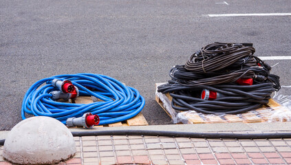 colored electric cables skeins. A bunch of  cable and a hank of  rope lie on the ground.