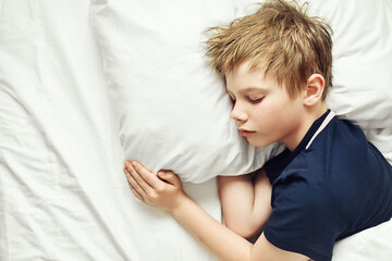 The child sleeps on a white bed