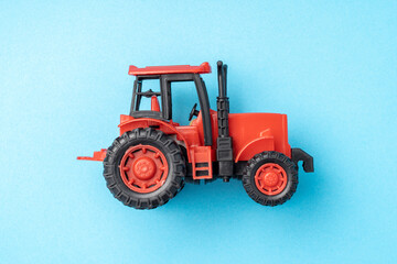red toy tractor on a blue background,