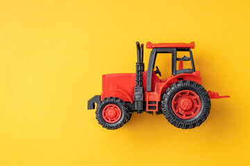 red toy tractor on a yellow background, banner.