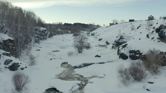 winter river with rapids and current, flying over thawed water and flowing in thawed water with waves