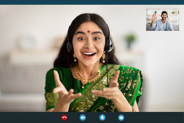 Screen view of young Indian woman in traditional sari making video call with male friend or husband...
