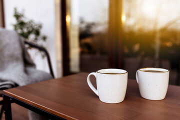 Two cups of coffee on the table on the wooden brown terrace