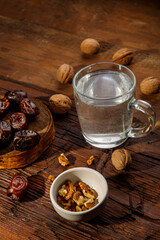 Food for iftar in ramadan on a wooden table dates, nuts and water.