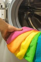 Person taking colored towels out of the washing machine