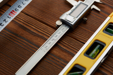 Level and caliper, macro view, wooden background