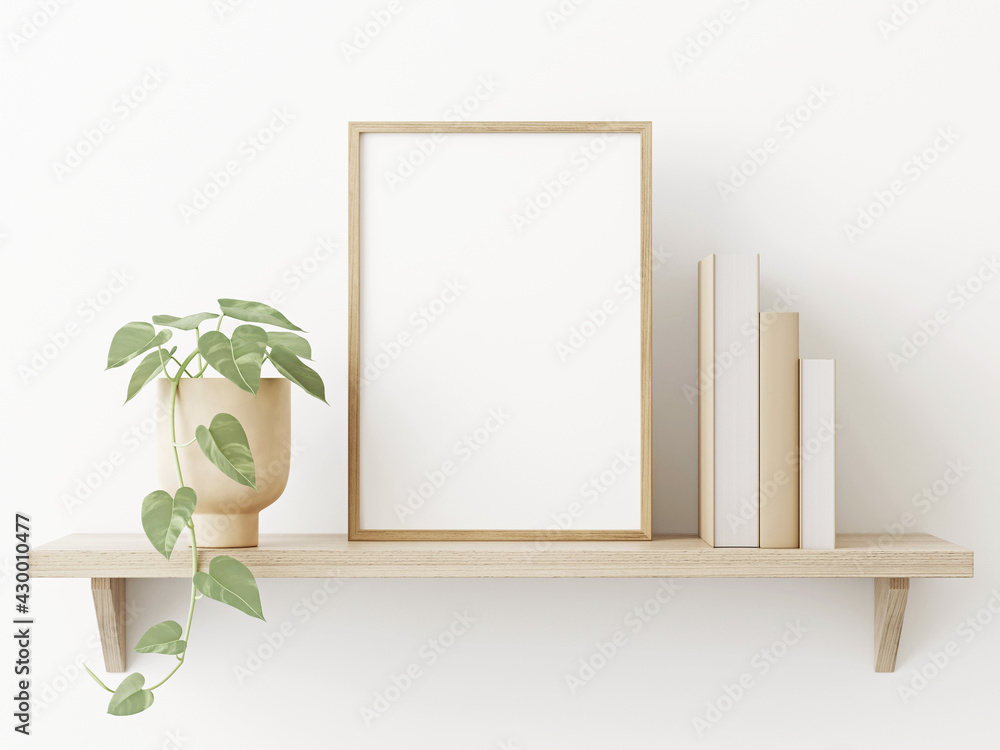 Poster small vertical wooden frame mockup in scandi style interior with trailing green plant in pot, pile o