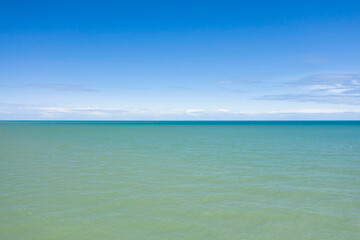 Fototapeta na wymiar La mer de la Manche et ses couleurs bleues et vertes en France, en Normandie, dans le Calvados, au bord de la Manche.