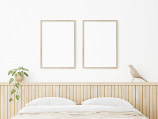 Vertical poster mockup with two wooden frames in Japandi style bedroom interior with beige slat headboard, trailing plant and bird on empty white wall background. 3D rendering, illustration