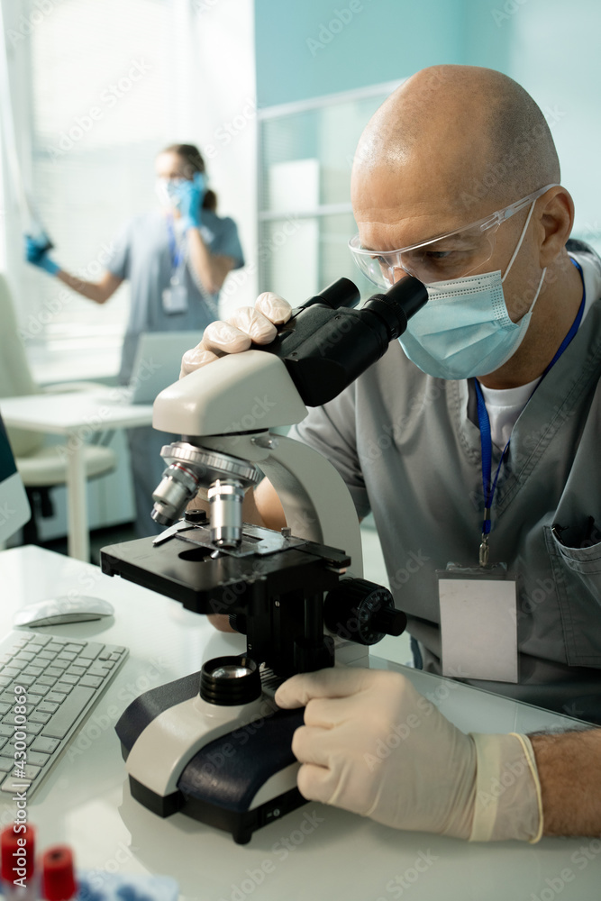 Poster Bald lab employee working with microscope