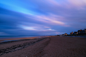 Fototapeta na wymiar La plage de Sword beach à Hermanville-sur-Mer avec des nuages qui bougent en France, en Normandie, dans le Calvados, au bord de la Manche.