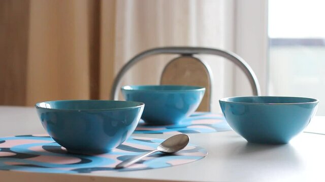 three blue plates on the table with hot porridge or soup that are steaming