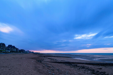 La plage de Sword beach à Lion-sur-Mer au coucher du Soleil avec les nuages qui bougent en France,...