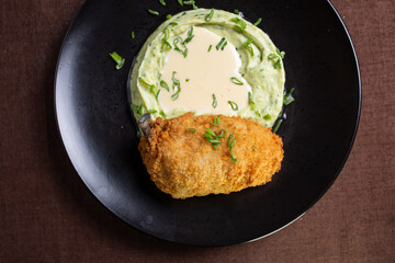 mashed potatoes with cutlet on Kiev on a black plate top view