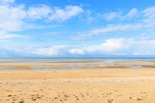 La plage de sable de Sword beach &agrave; Ouistreham sous un ciel avec des nuages en France, en Normandie, dans le Calvados, au bord de la Manche.