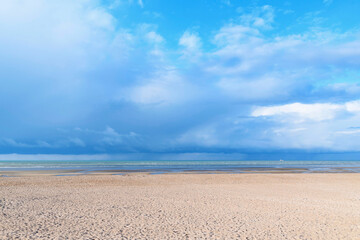 Fototapeta na wymiar La plage de Sword beach à Ouistreham sous un ciel avec des nuages orageux en France, en Normandie, dans le Calvados, au bord de la Manche.