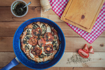 Artisan pizza with healthy ingredients like tomato, aubergine and pesto sauce