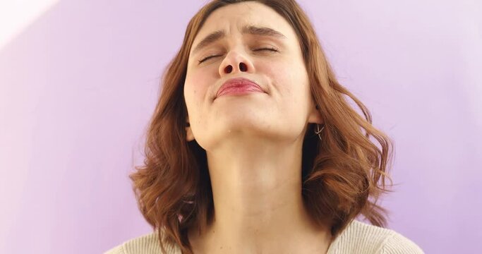 Tired sleepy woman yawns, covers her mouth with hand. Curly short hair girl stretches hands up. Very boring, uninteresting. Violet studio background.