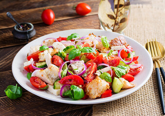 Tuscan Panzanella, traditional Italian salad with tomatoes and bread on wooden background. Vegetarian panzanella salad. Mediterranean healthy food.