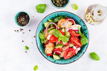 Traditional italian tomato salad panzanella with mozzarella, capers, red onion and croutons. Summer salad. Tuscan salad. Top view, above, copy space