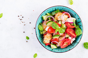 Traditional italian tomato salad panzanella with mozzarella, capers, red onion and croutons. Summer salad. Tuscan salad. Top view, above, copy space