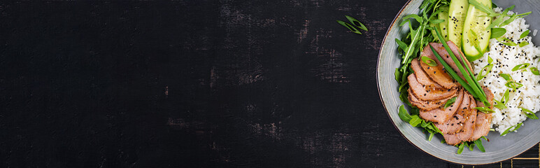 Homemade baked sliced beef and rice bowl with salad. Diet menu. Top view, banner