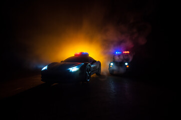 Police car chasing a car at night with fog background. 911 Emergency response police car speeding to scene of crime. Selective focus