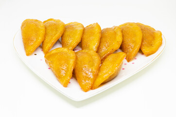 Qatayef Ramadan Or katayef Traditional Arabic  Sweets cheese and brown Cinnamon sticks on white dish isolated on white background
