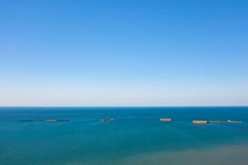 Les éléments du port artificiel de Arromanches les bains au niveau de Asnelles dans la mer en France, en Normandie, dans le Calvados, au bord de la Manche.