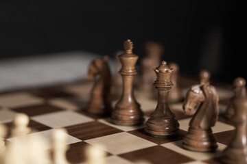 Chess, queen, Chess pieces are located on a wooden board. close-up side view queen, think