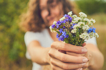 Girl holding a bouquet of wildflowers. Collected wildflowers in a small bouquet held by a girl