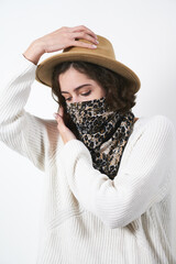 Face shield as a stylish and fashionable virus protection. Pretty girl in a brown hat. Leopard shawl protective mask