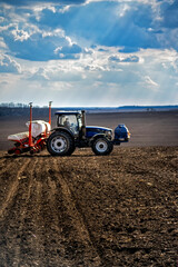 sowing work in the field. Tractor with seeder