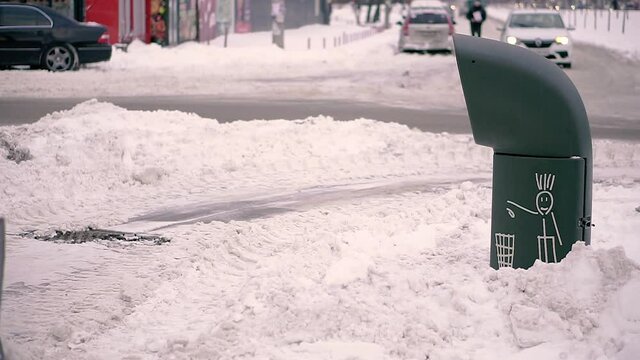 Garbage can. Trash can on the background of a snow-covered city.